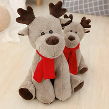 Two plush reindeer toys with red scarves on a light wooden floor.