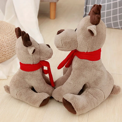 Two plush deer toys with red scarves sitting on a light wooden floor.