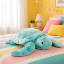Blue plush turtle toy laying on a colorful bed in a colorful room with yellow walls