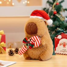 Plush Capybara toy wearing a Santa hat with Christmas decorations in the background