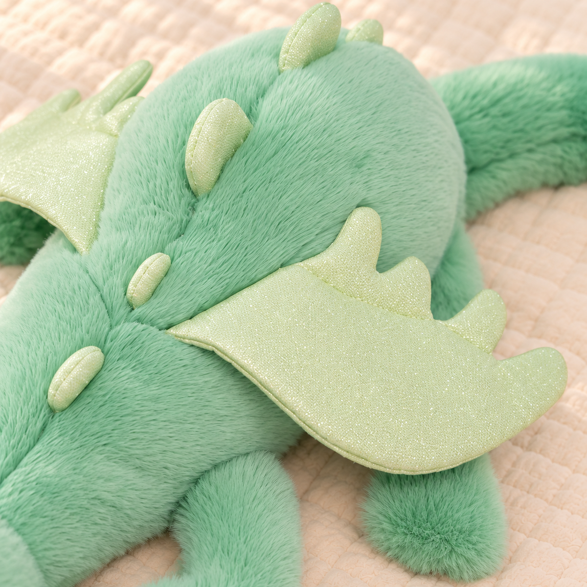 Close-up of the Mint Green Dreamwing dragon’s pale green wings and small back spikes.