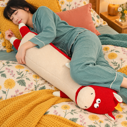 Woman in teal loungewear resting across a cherry red and cream Happy-Go-Hippo body pillow on floral bedding, showing its full 95cm / 3.1 feet scale in use.