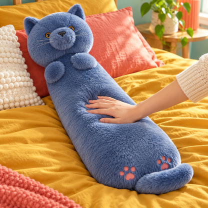 Close view of a hand gently pressing the blue gray cat Hug-Me body pillow on mustard bedding, showing its plush surface and embroidered pink paws.