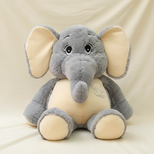 Plush elephant toy with gray body and beige ears and feet on a beige background
