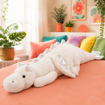 White Mythic Hugs giant dragon plushie with pearly-silver accents on a coral bed.