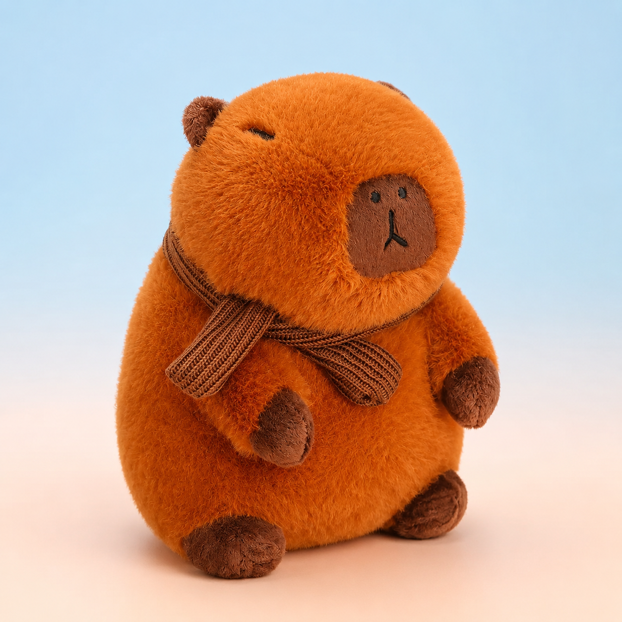 Brown 12-inch capybara plushie wearing a knitted scarf