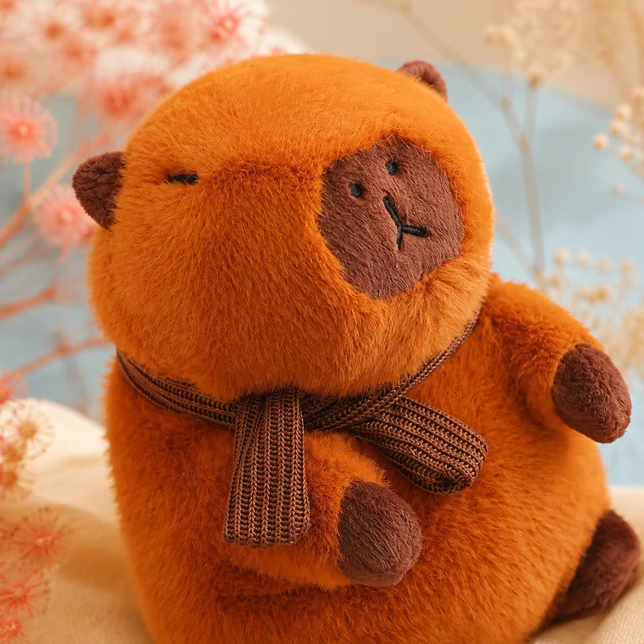 Soft fur and knitted scarf detail on the capybara plushie