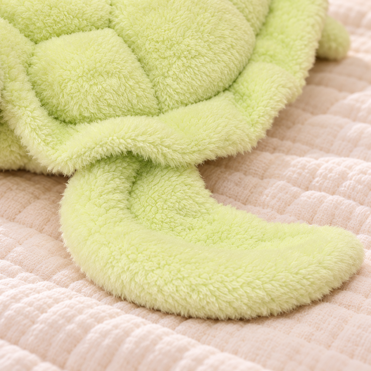 Detail of the Snuggle Shell turtle’s wide curved front flipper and soft plush shell edge.