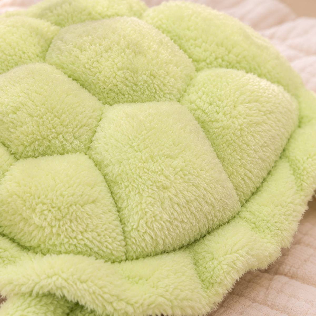 Close-up of the Snuggle Shell turtle’s fuzzy green fabric and softly raised shell panels.