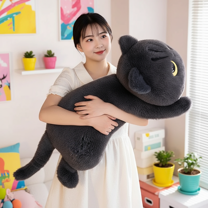 Woman holding a large gray cat-shaped plush toy in a room with colorful decor.