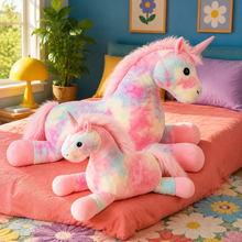 Starblush unicorn plushies in both sizes displayed together in a colorful bedroom.