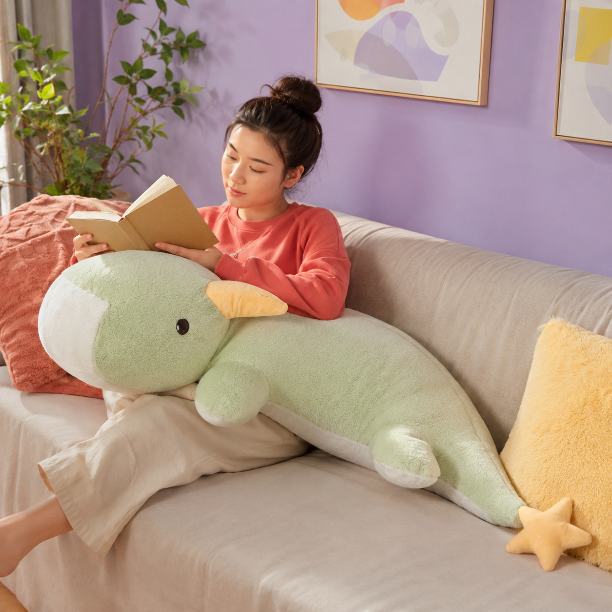 Adult reading with the 130cm mint green Starry Snooze long dragon plushie body pillow on a cream sofa
