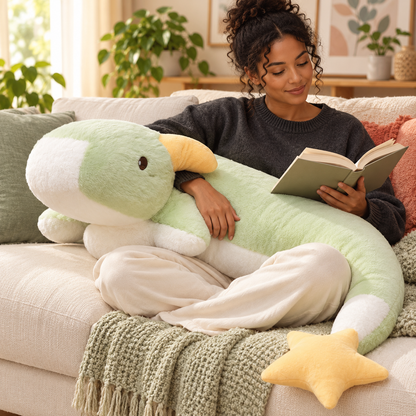 Adult reading on a sofa with a Mint Green Starry Snooze long dragon plush body pillow across her lap